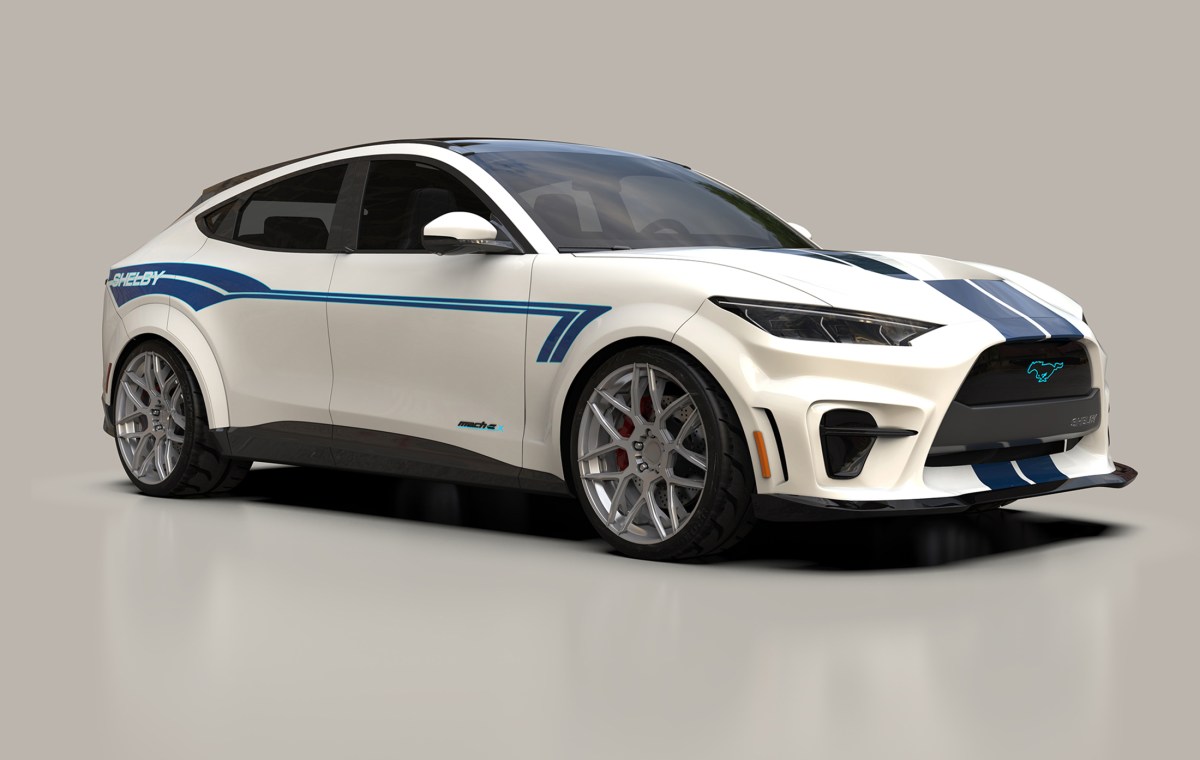 A 2021 Ford Mustang Mach-E with a custom body kit from Shelby American which features a re-worked front fascia with a wider opening, fender flares, 19-inch wheels, white paint, with blue stripe graphics. This car will be on display at SEMA 2021
