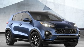 A blue 2022 Kia Sportage parked in front of a white background.