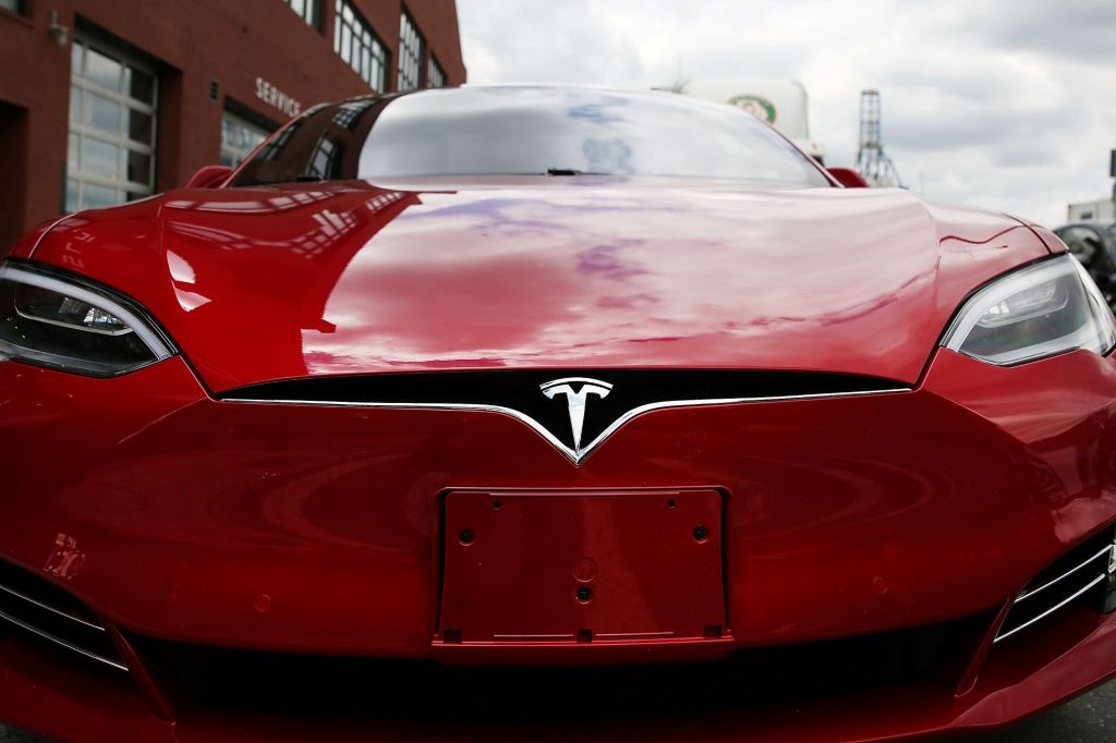 Red front of a Tesla using a wide angle lens.