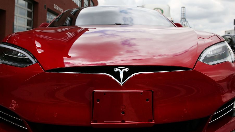 Red front of a Tesla using a wide angle lens.