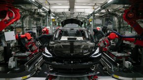 Tesla Model 3 sedan being assembled by robots. Tesla production was up to record levels in Q3 2021