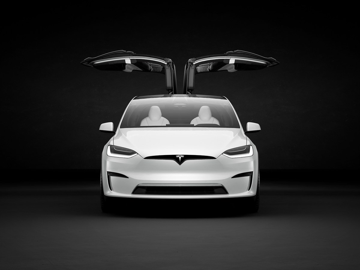 Tesla Model X in white seen from the front with its unique gullwing doors open