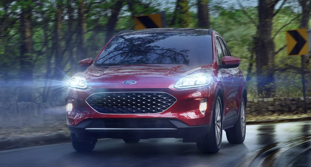 A red 2021 Ford Escape SE Hybrid is driving through the rain. 
