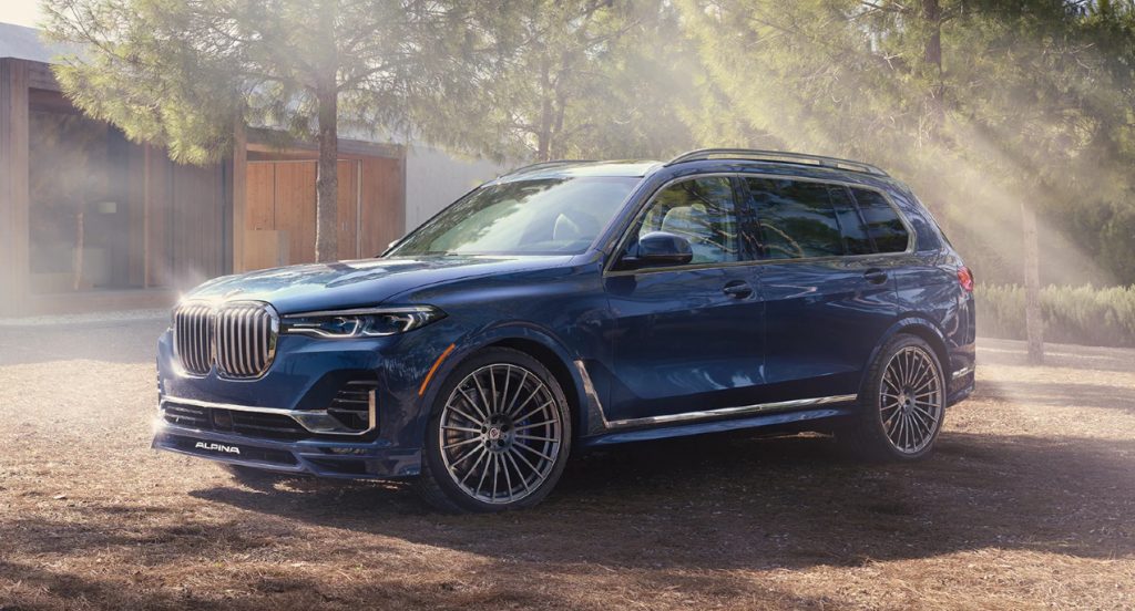 A blue 2022 BMW X7 is parked outdoors in the sunshine. 
