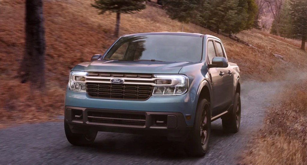A blue 2022 Ford Maverick driving through the woods, it's a great small pickup truck.
