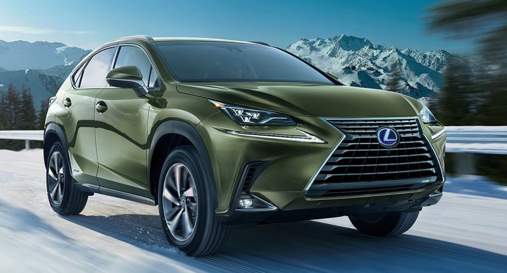 A green 2022 Lexus NX is driving on a snowy highway. 
