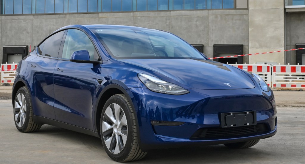 A blue Tesla Model Y electric vehicle stands at the construction site of the Tesla Gigafactory Berlin-Brandenburg.