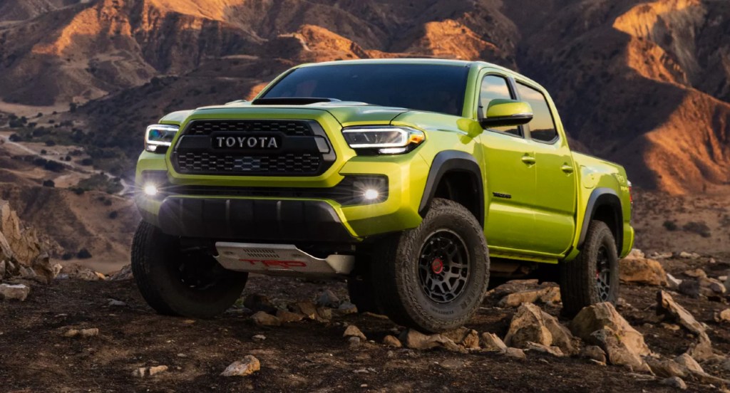 An Electric Lime Metallic 2022 Toyota Tacoma TRD Pro is driving over rocks. 