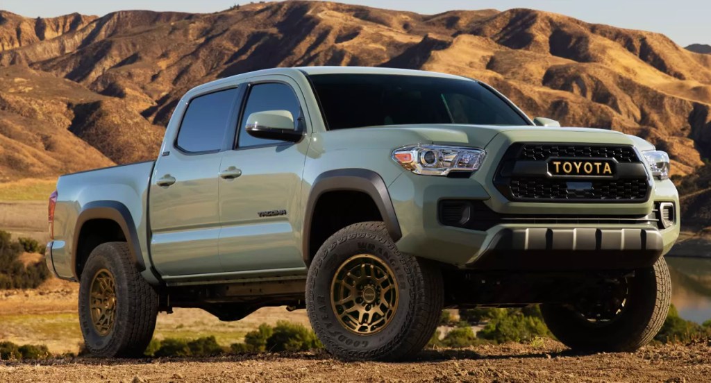 A moss green Toyota Tacoma in a desert.