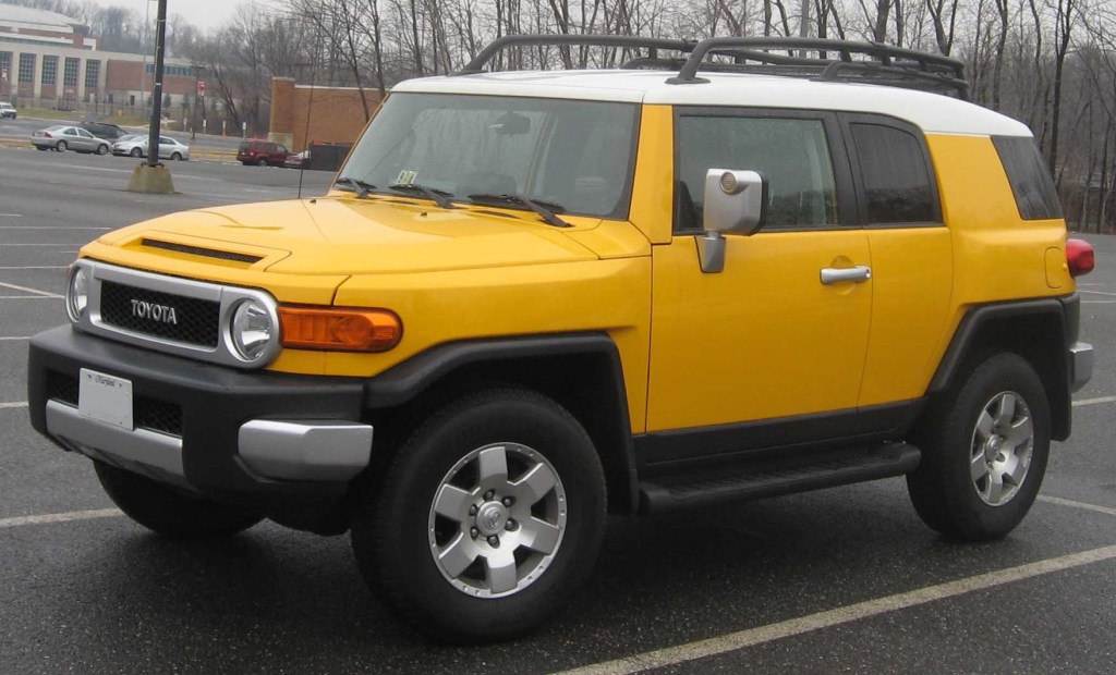 A discontinued yellow Toyota FJ Cruiser parked outside in a parking lot