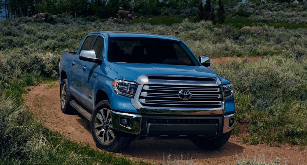 A blue 2022 Toyota Tundra is driving off-road. It has an increased price and better fuel economy.