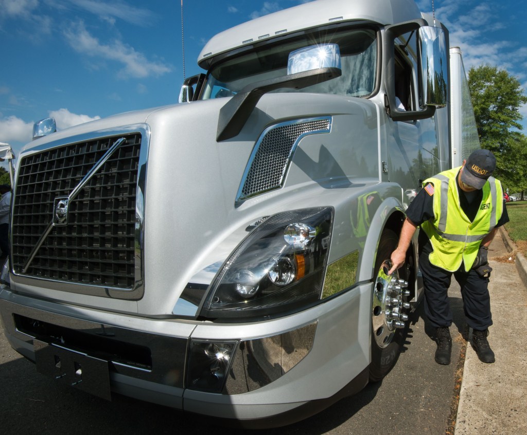 Trucker Inspects A Semi-Truck's Spiked Rim