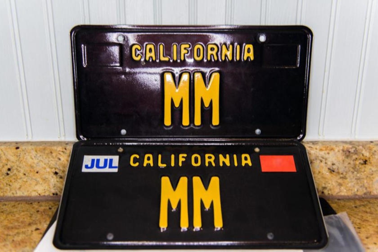 Two black and yellow California vanity license plates with the letters "MM"