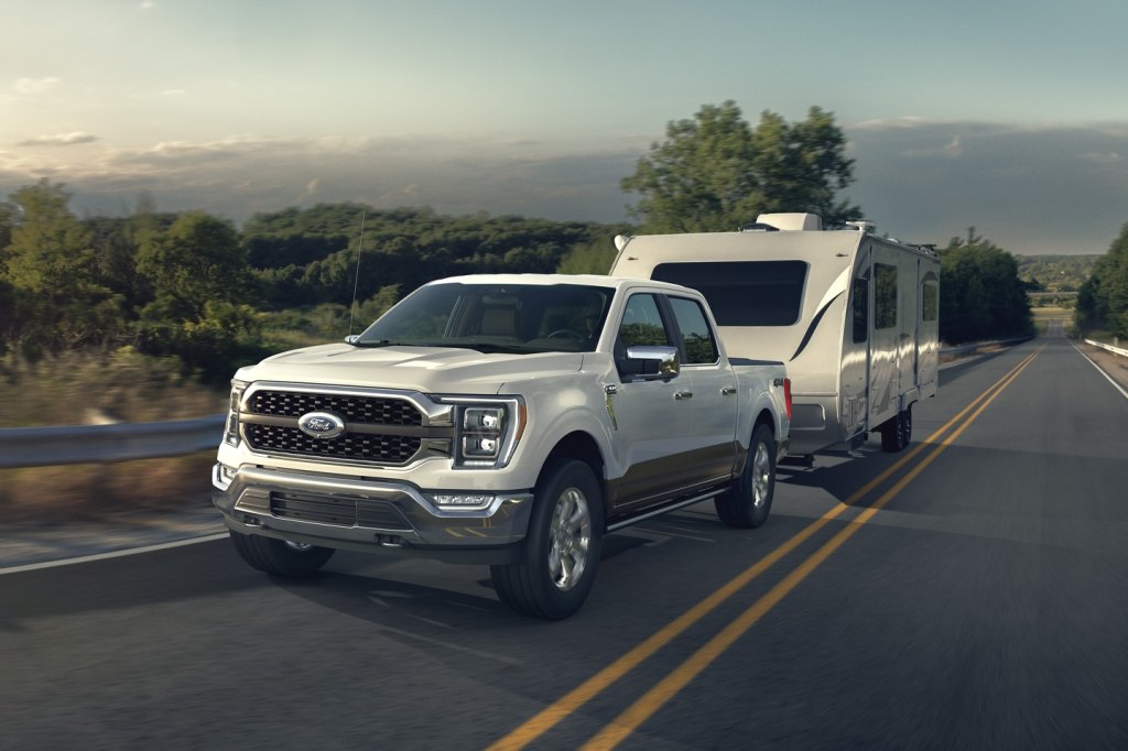 White 2021 Ford F-150 towing a camping trailer
