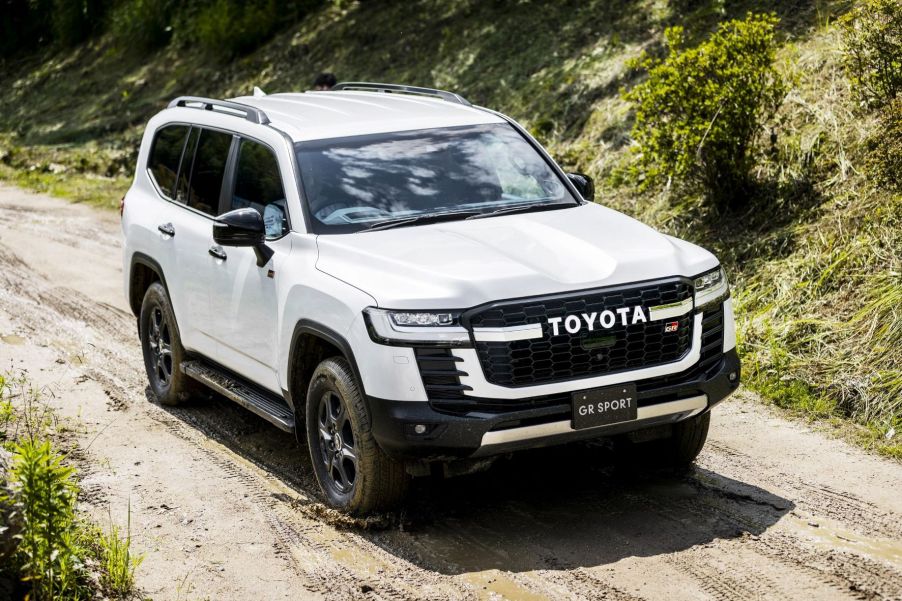 White 2022 Toyota Land Cruiser driving on a muddy road