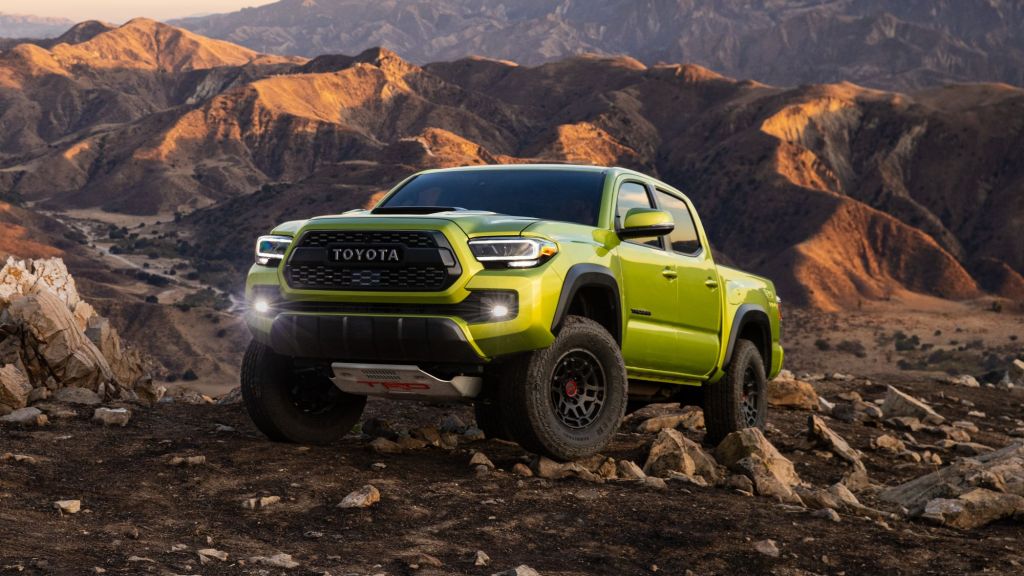 Yellow 2022 Toyota Tacoma pickup truck with mountains in the background