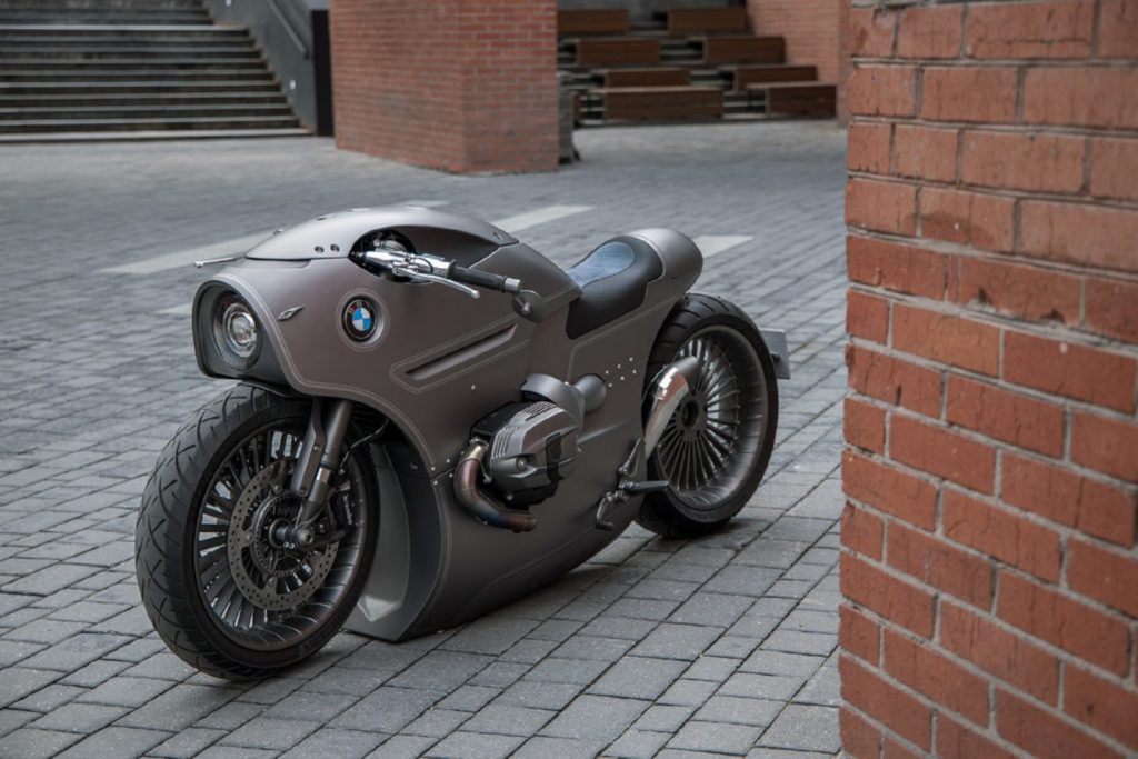 Zillers Garage's gray custom BMW R nineT '801' parked on a cobblestone street next to a red brick building