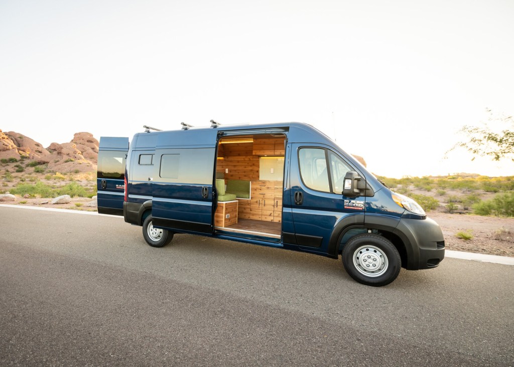 A converted RAM ProMaster van from Boho campers next to a desert