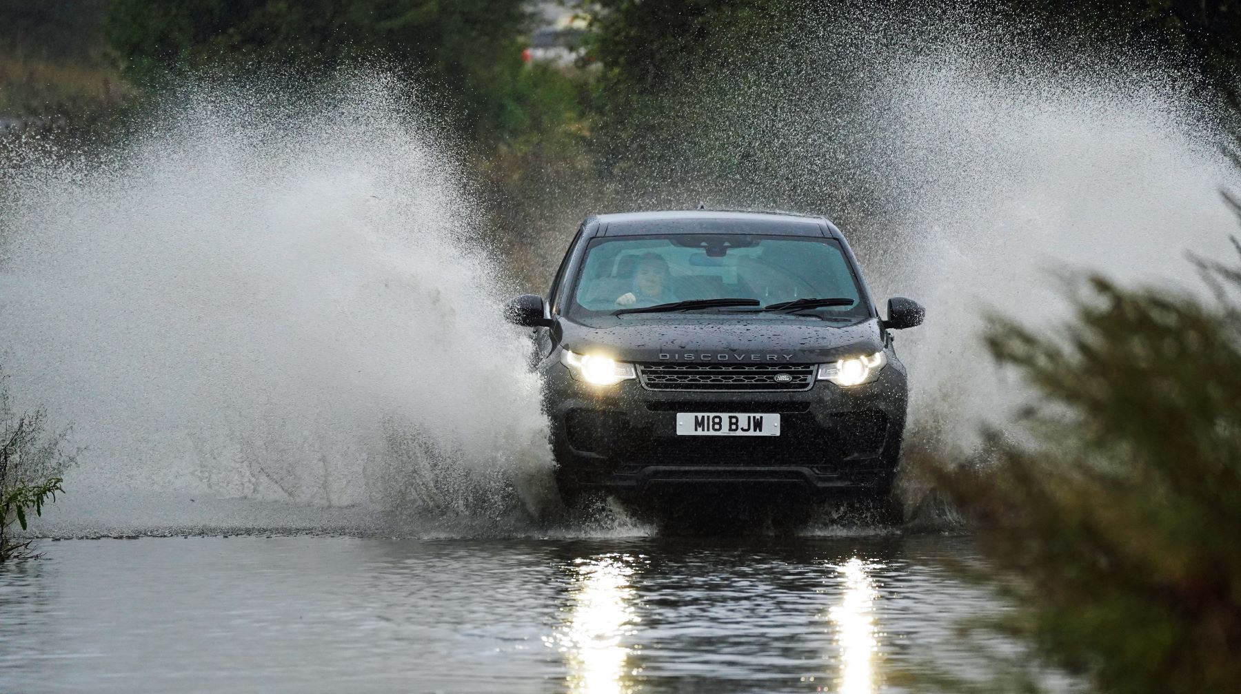 A Land Rover Discovery driving through floodwaters in Whitley Bay, North Tyneside