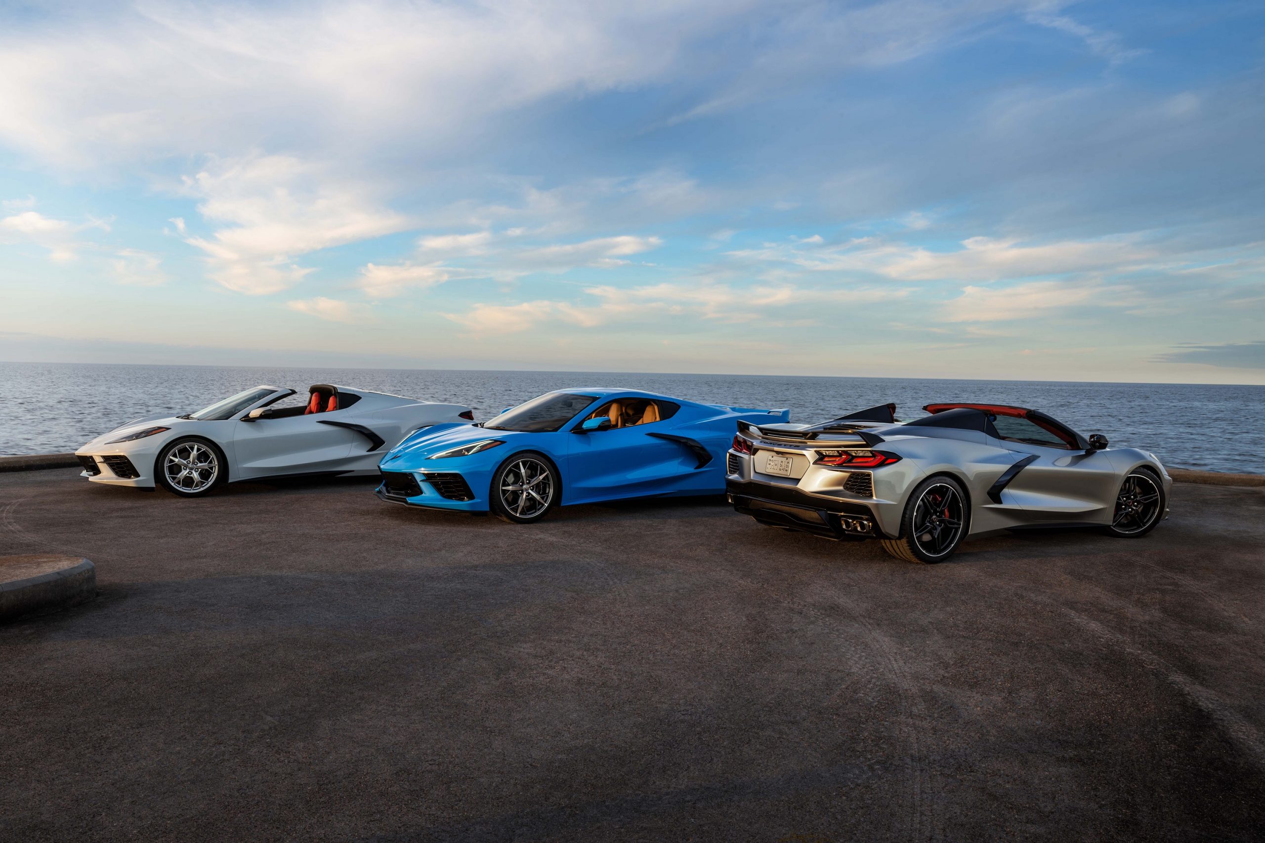 A trio of Chevrolet Corvette models shot at the 3/4 angle by the sea