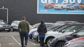 Potential customers walk around a car lot