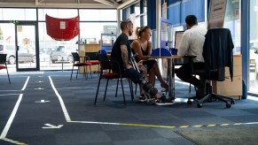 customers sitting a car salesperson's desk