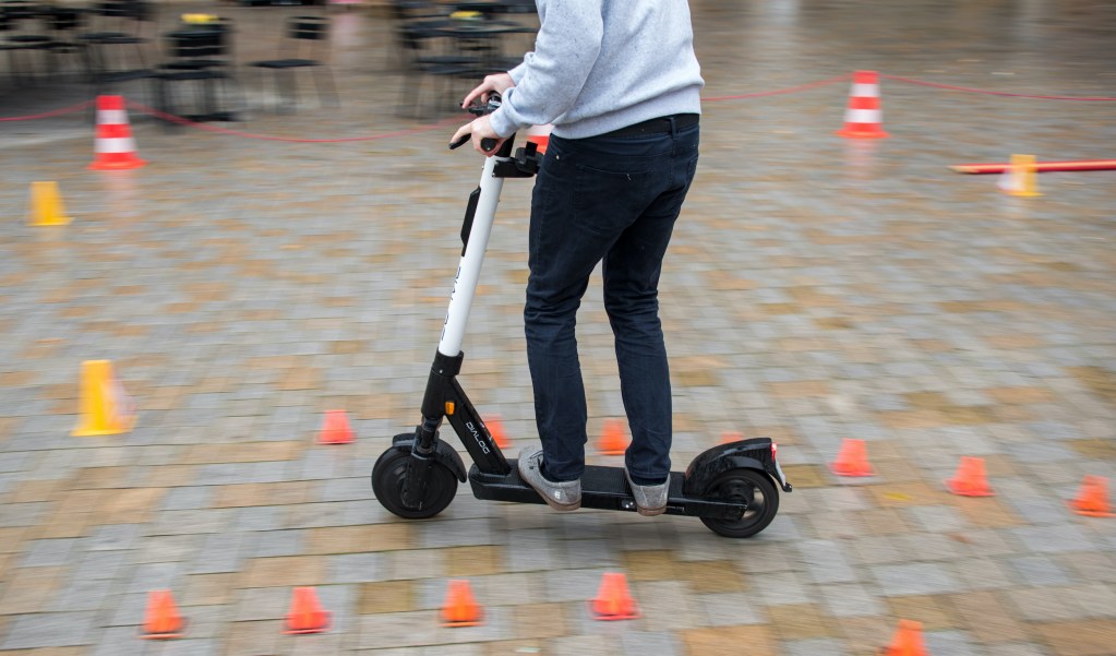 An employee of an e-scooter supplier drives through an obstacle course during a driver safety training course. 