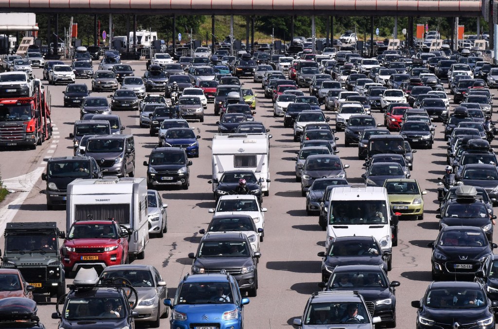 Motorists drive and queue in their vehicles at a toll station on the A7 motorway between Lyon and Vienne, southeastern France, during a heavy traffic jam on the first major weekend of the French summer holidays.