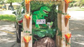 Jurassic Park trunk-or-treat decorations for a car.