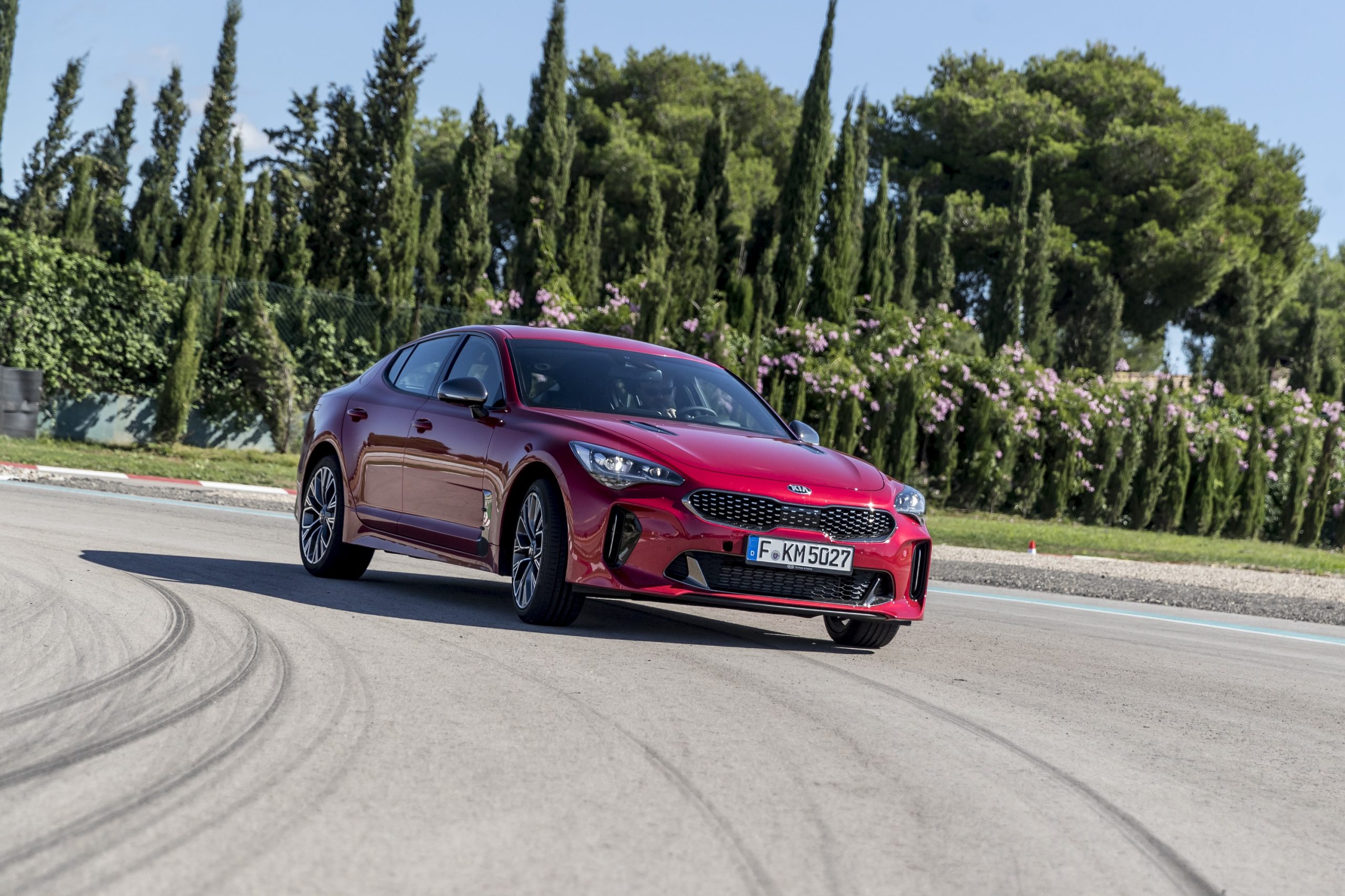 A red Kia Stinger shot from the front 3/4 in Mallorca