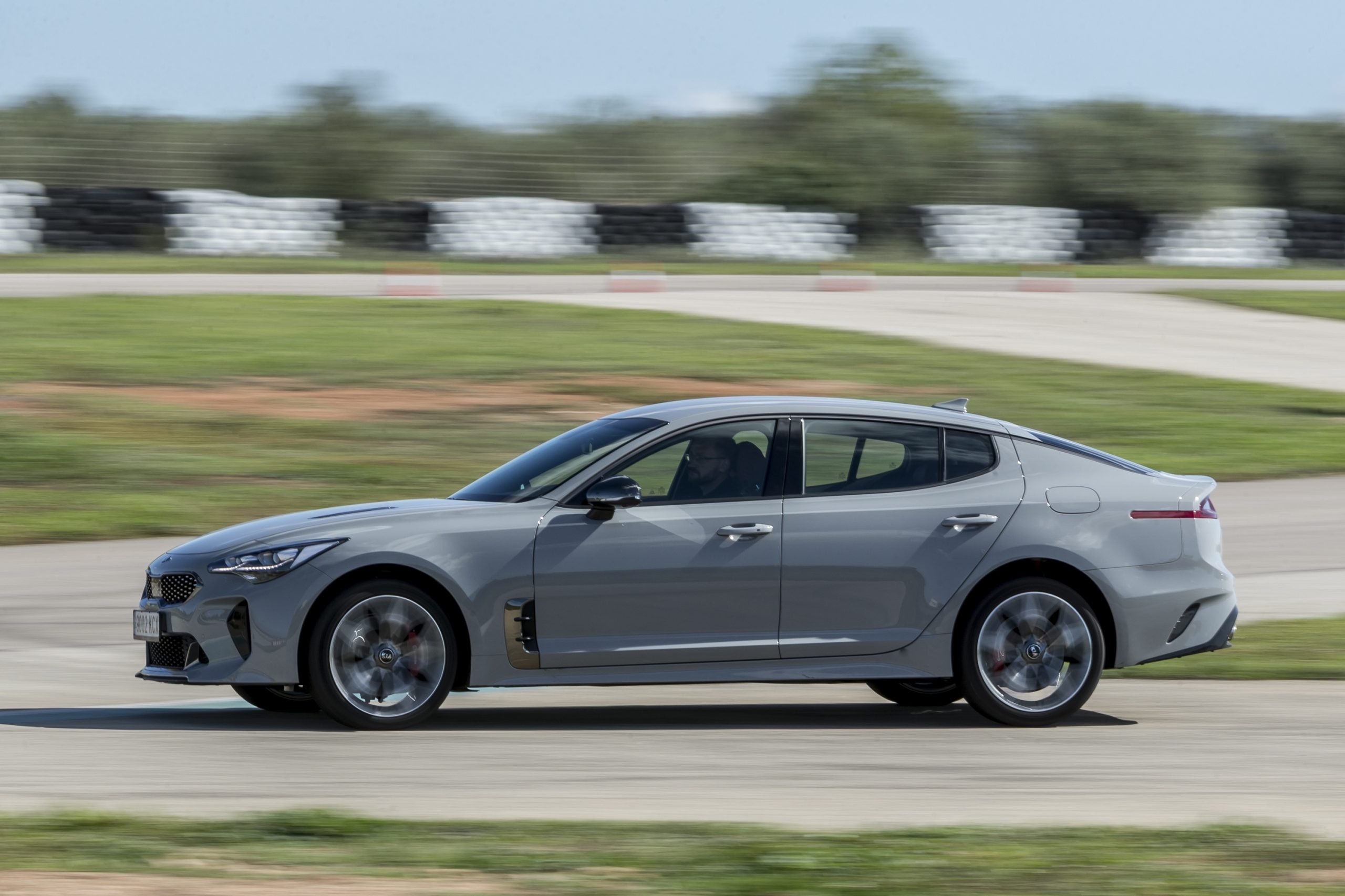 A grey Stinger races down a test track, shot in profile