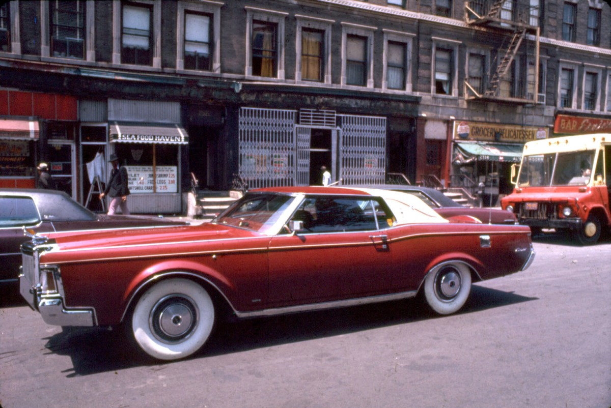 A customized Lincoln-Continental driving on a street in Harlem, New York