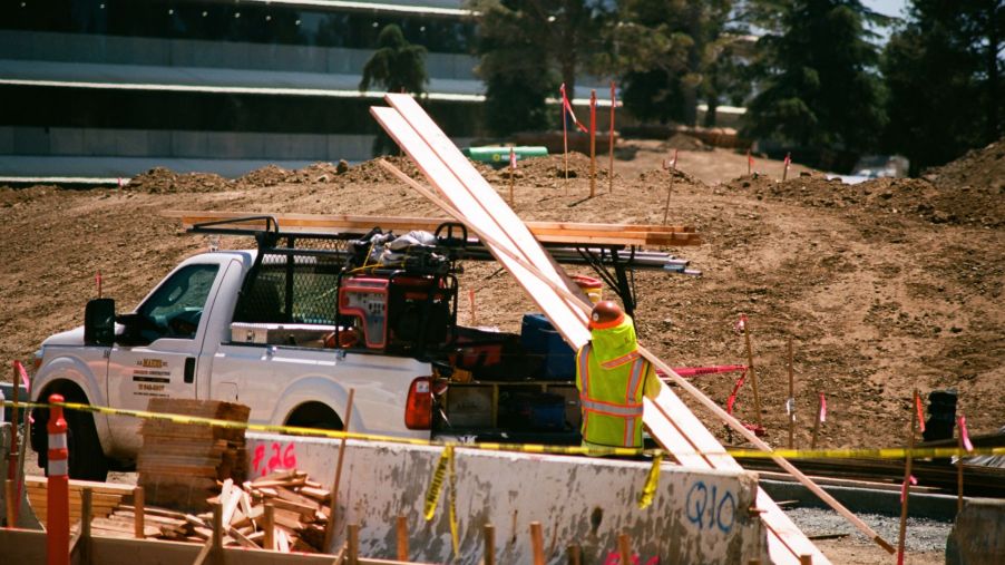 A construction worker loading up a pickup truck with equipment and materials
