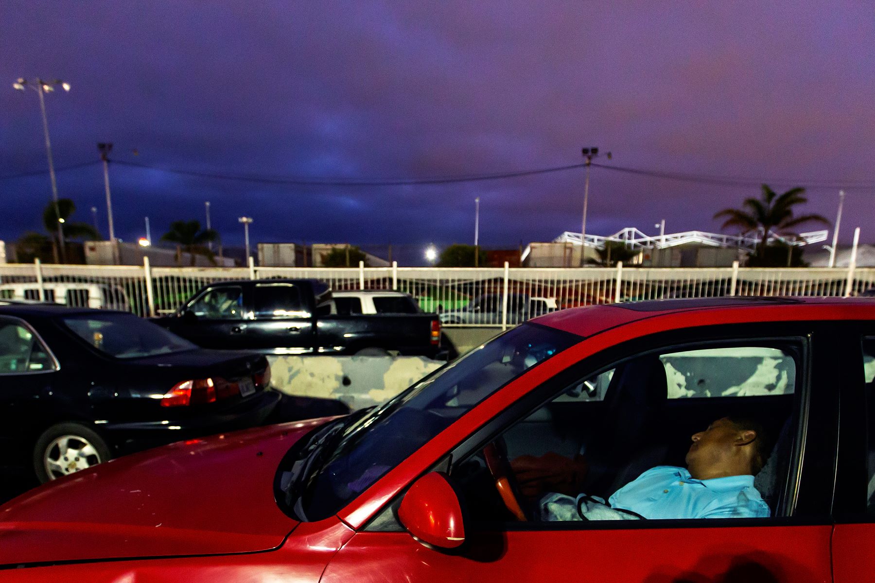 A man sleeping in a car at the Otay Mesa Port of Entry in Tijuana, Mexico