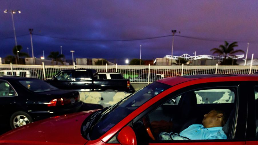 A man sleeping in a car at the Otay Mesa Port of Entry in Tijuana, Mexico