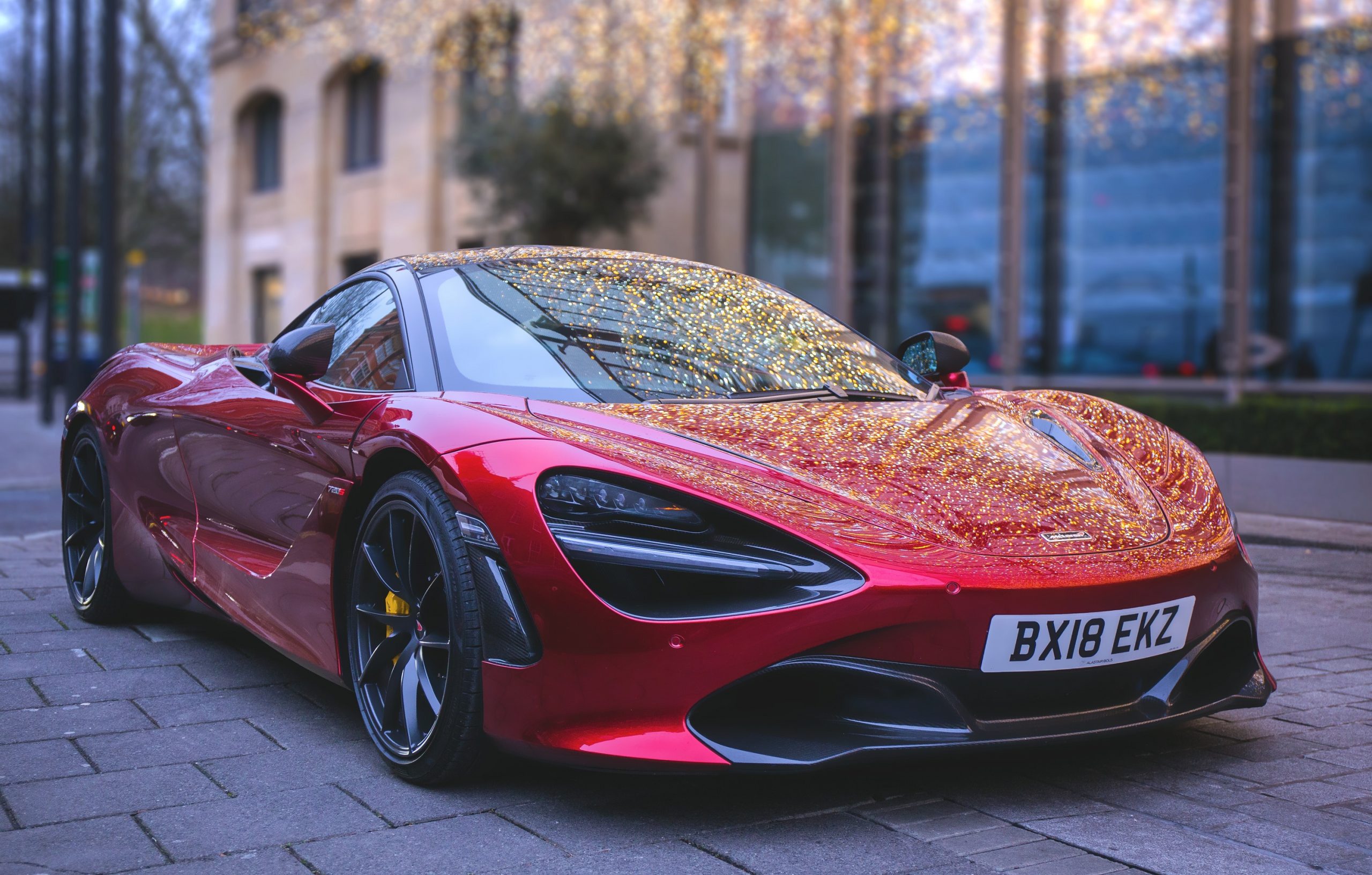 A red McLaren 720s parked up in London, shot from the front 3/4