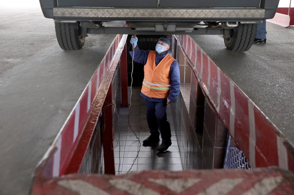 A mechanic examines an ambulance at the Kyivmedspetstrans Communal Enterprise, Kyiv, capital of Ukraine.