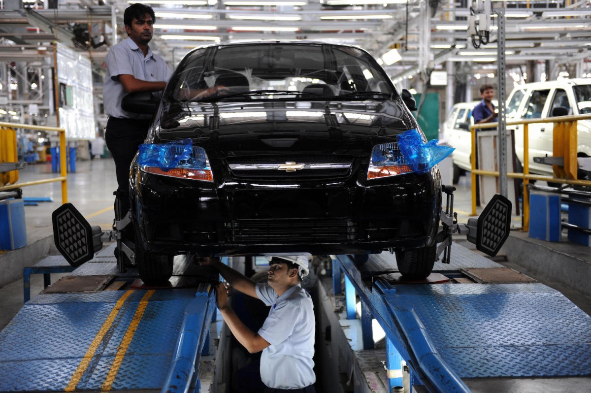 Mechanics balancing a car's wheels