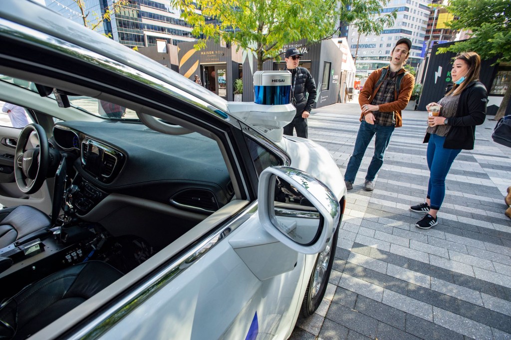 Event attendees inspect an autonomous car by Motional at the Robot Block Party put on by MassRobotoics in Boston, Massachusetts on October 2, 2021.