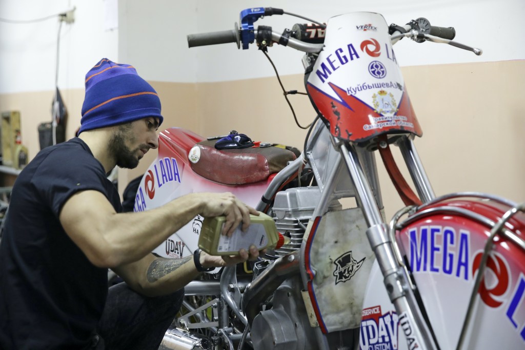 A participant prepares his vehicle for the start of a men's class 500 race in the first final of the Russian Ice Speedway Cup at a motorcycle racing track of the Russian Volunteer Society for Cooperation with the Army, Aviation, and Navy (DOSAAF).