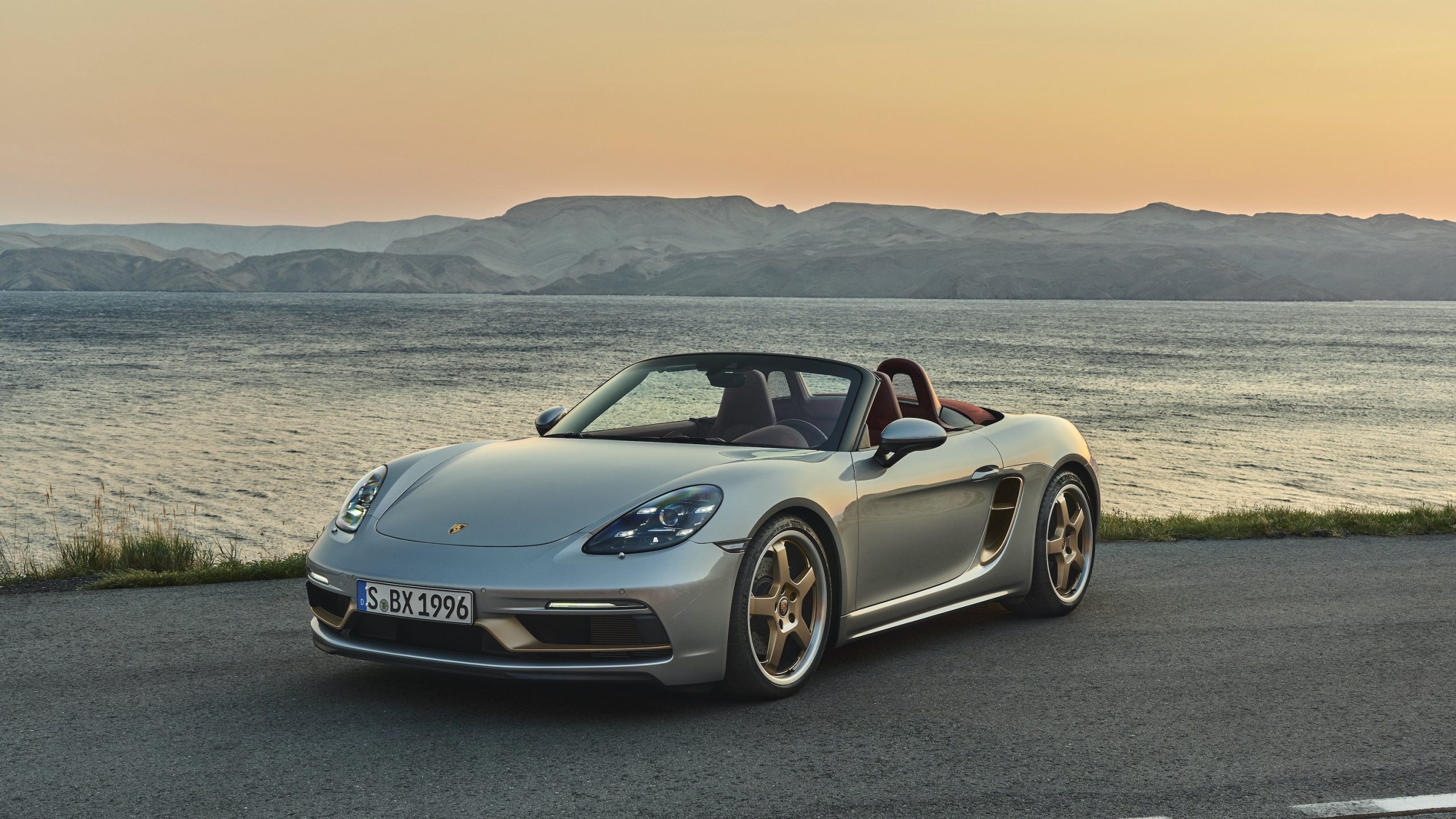 The 2022 Porsche Boxster Anniversary shot from the front 3/4 in silver with bronze wheels at sunset