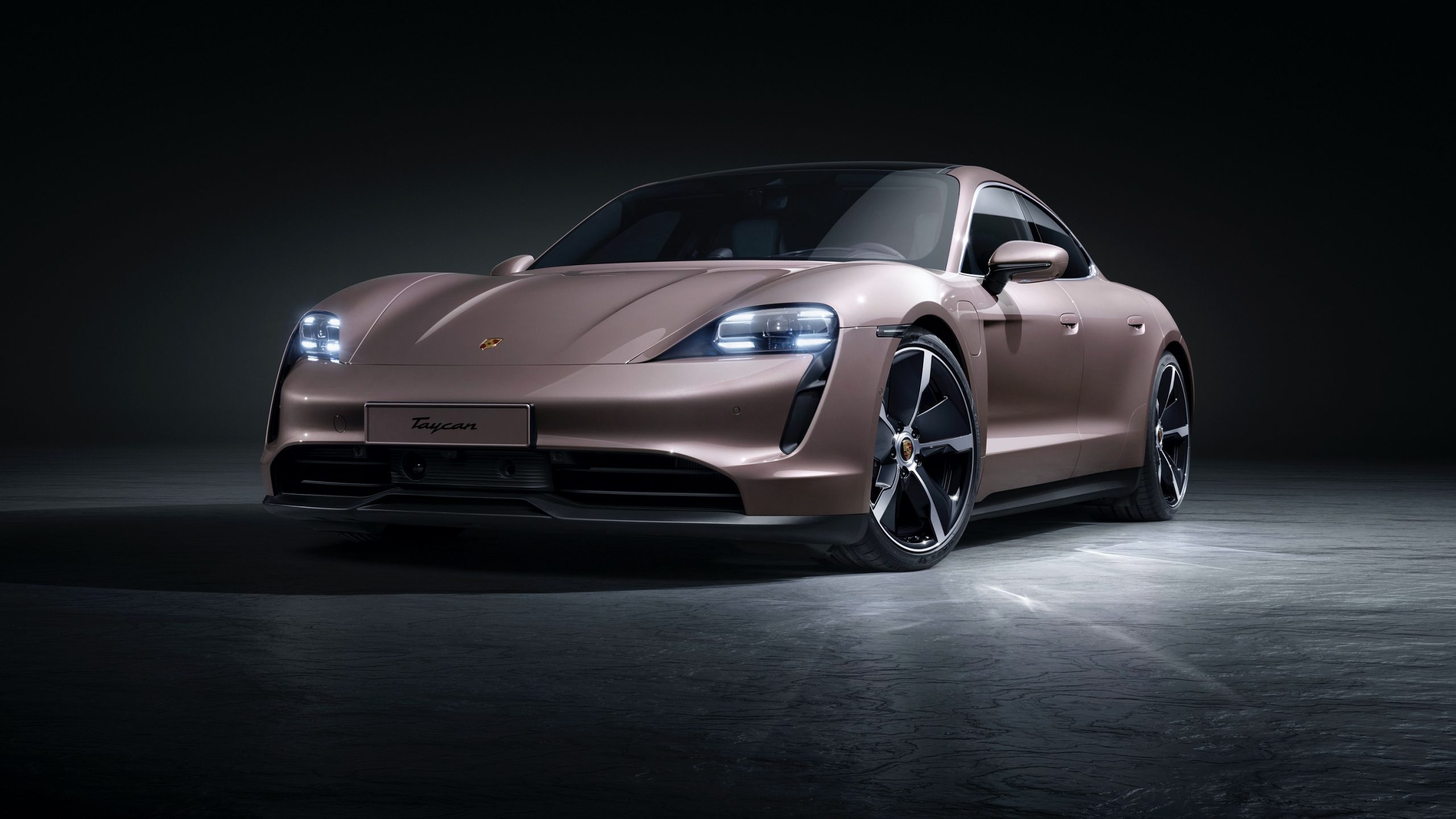 The 2021 Porsche Taycan shot from the front 3/4 in a studio with frozen berry paint
