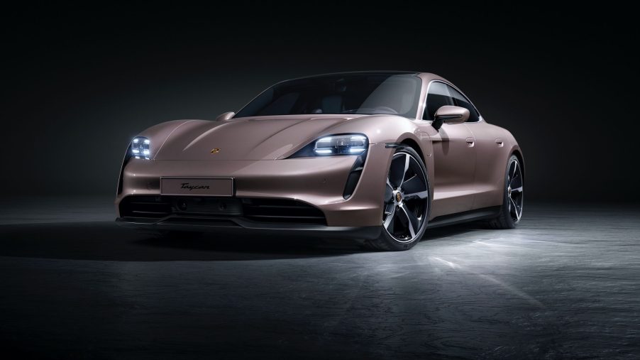The 2021 Porsche Taycan shot from the front 3/4 in a studio with frozen berry paint