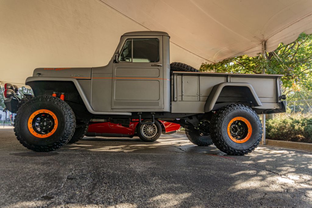 The side view of a gray 1955 Willys-Overland Jeep Truck restomod at the 2021 Mecum Chicago auction