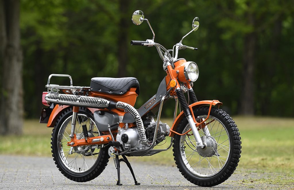 An orange-and-gray 1973 Honda 'CT90' Trail 90 in a parking lot