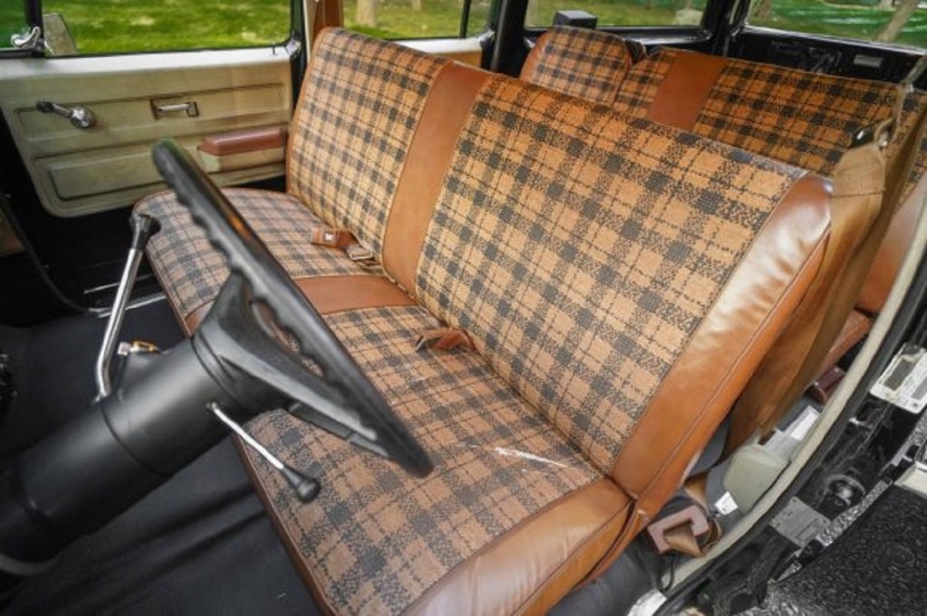 The brown plaid interior of a 1976 GMC Suburban Sierra.