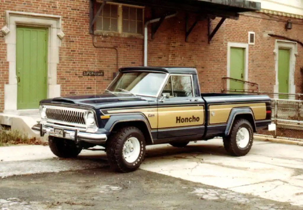 A black-and-gold 1976 Jeep J10 Honcho in an industrial parking lot