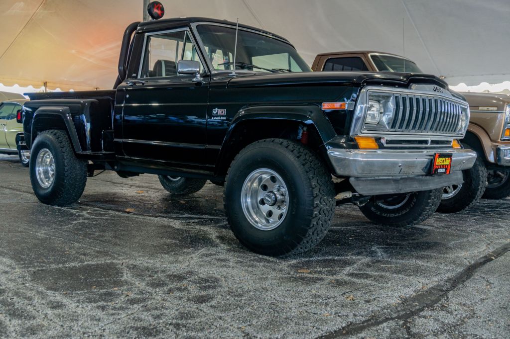 The front 3/4 view of a black restored 1981 Jeep J10 at the 2021 Mecum auction in Chicago
