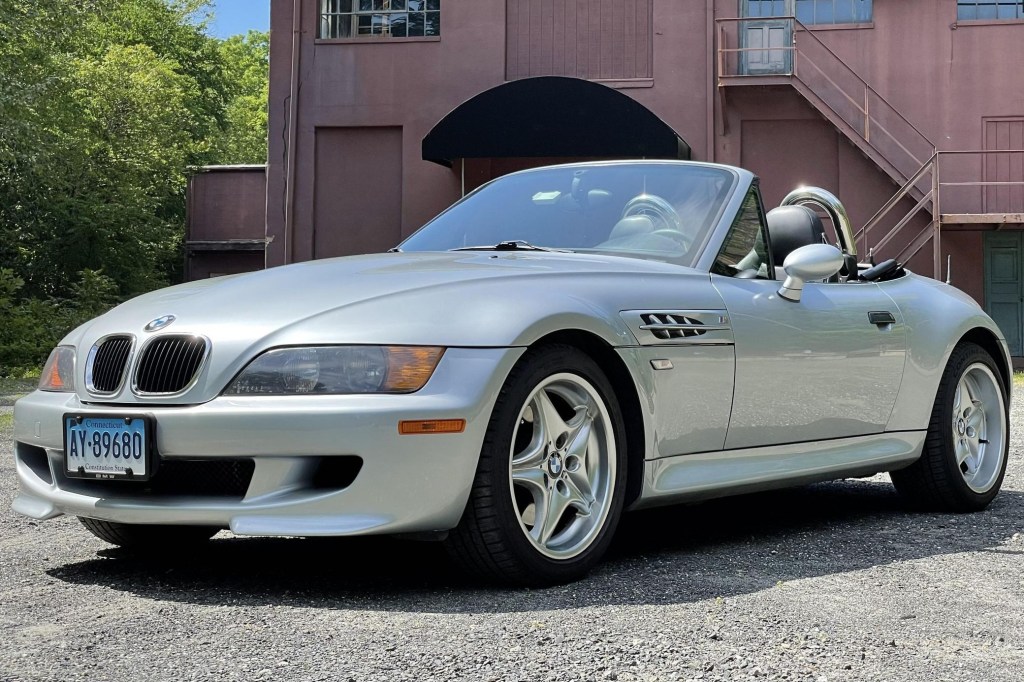 A silver 1998 BMW Z3 M Roadster in front of a red building