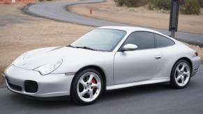 A silver 2003 Porsche 911 Carrera 4S parked by a winding road